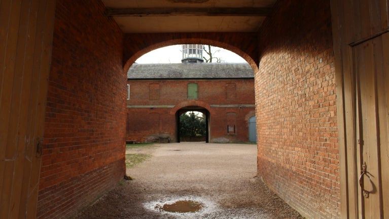 Looking through the archway into the Stableyard at Calke Abbey, Derbyshire